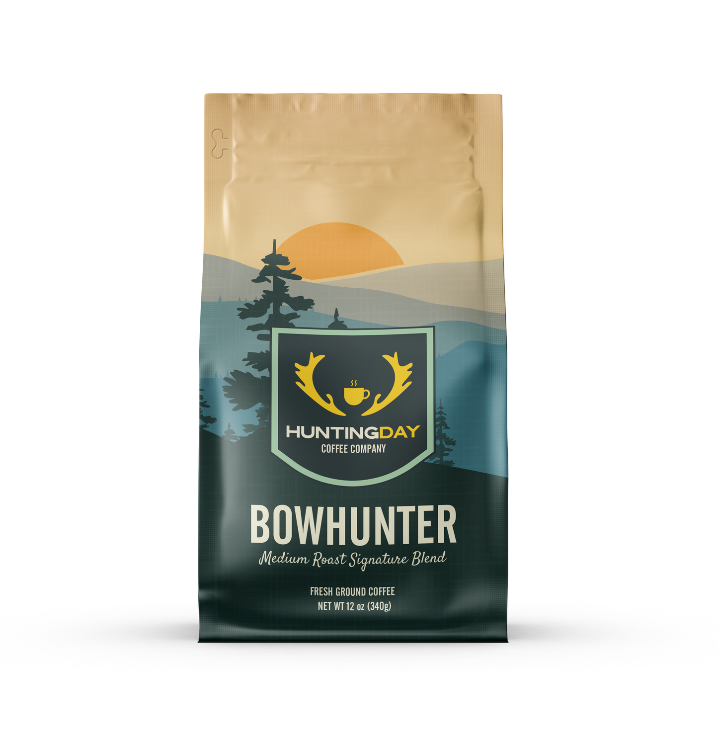 A bag of Huntingday Coffee Company 'Bowhunter' medium roast coffee, featuring a landscape design with a golden sun, pine trees, and a dark teal mountain range.