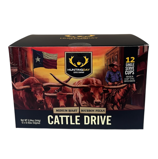 A boxed beverage product labeled HARTMODAY CATTLE DRIVE, shown against a plain white background. The box features a western illustration with longhorns, an American flag, a cowboy in a blue shirt, and the text 'CATTLE DRIVE' and 'MEDIUM ROAST BOURBON PEANUT'.