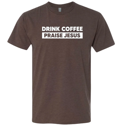 A dark brown heather crewneck t-shirt with a white graphic print on the chest that reads 'DRINK COFFEE PRAISE JESUS' in bold uppercase letters, shown against a plain white background.