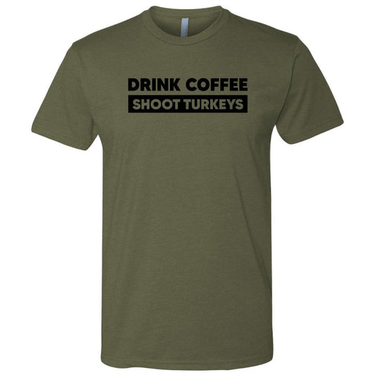 An olive green short-sleeve t-shirt with a black graphic text print on the chest that reads 'DRINK COFFEE SHOOT TURKEYS'. The t-shirt is displayed on a clean white background.