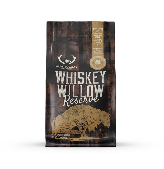 A bag of Huntingday Coffee Company Whiskey Willow Reserve whole bean coffee, featuring a dark brown and black rustic design with gold and white text and graphics.